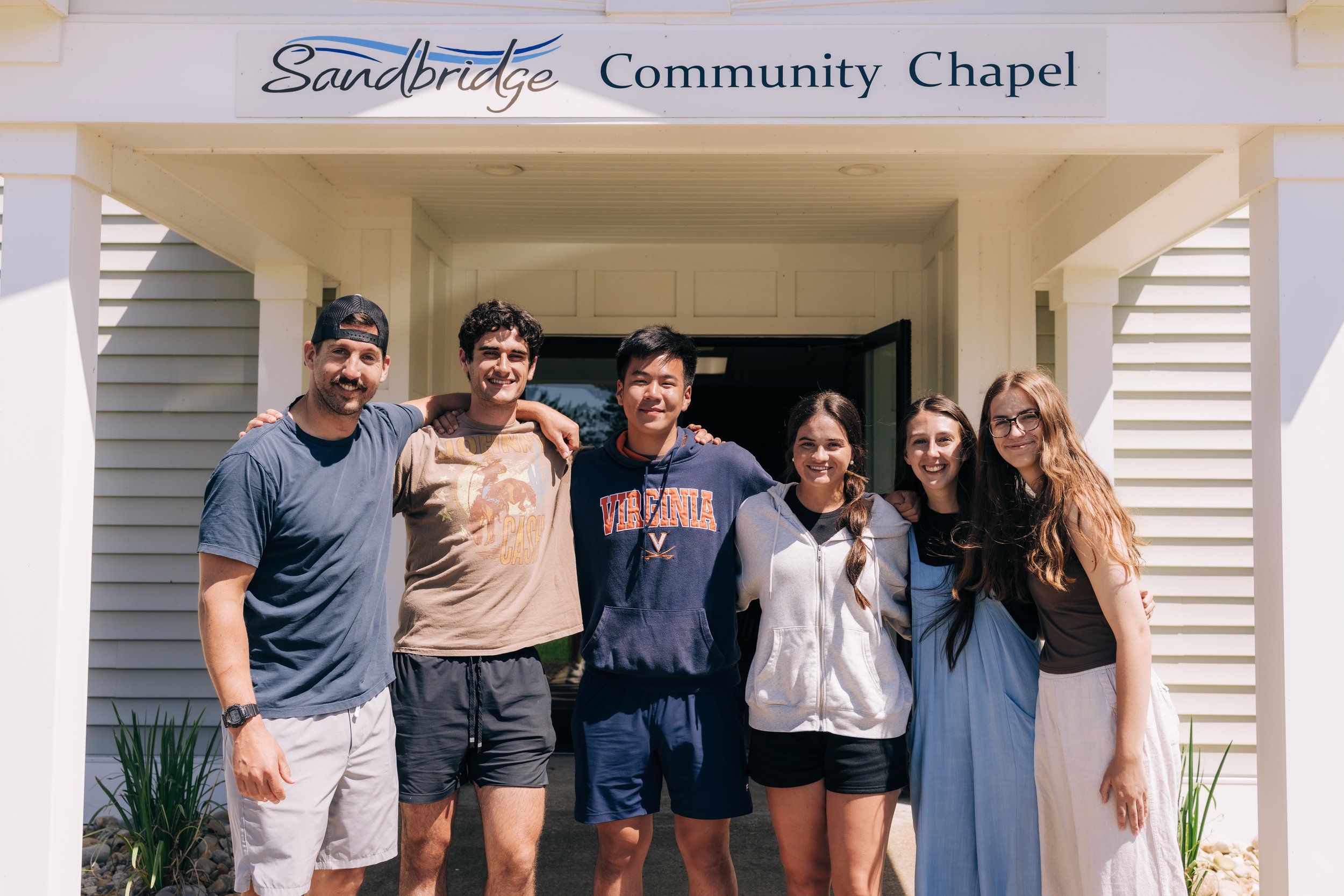 Campus Outreach students and staff standing together arm in arm in a church doorway near the University of Virginia