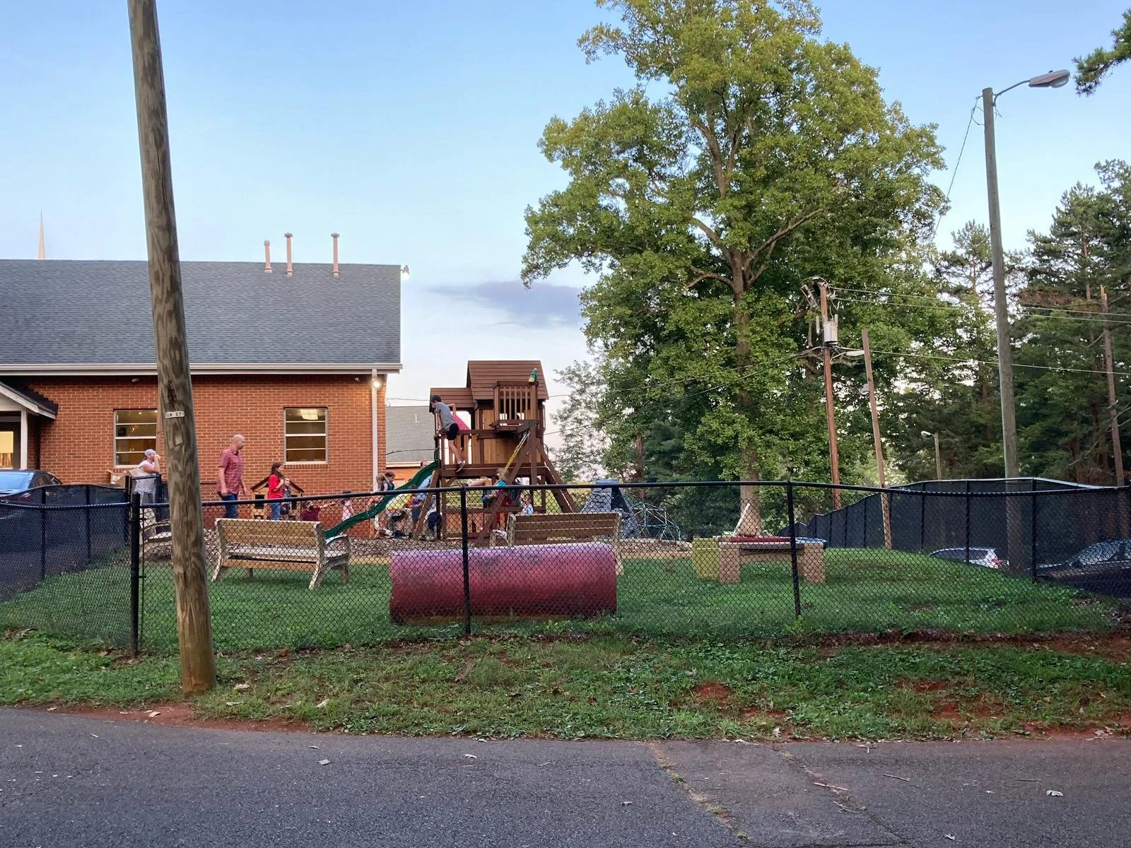 Children playing on the new playground beside the church building